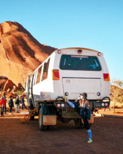 Off-road tour bus parked at the base of Uluru